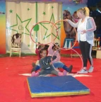 Hund springt über Kinder durch den Reifen