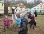 Kinder mit Lamas und Ziegen